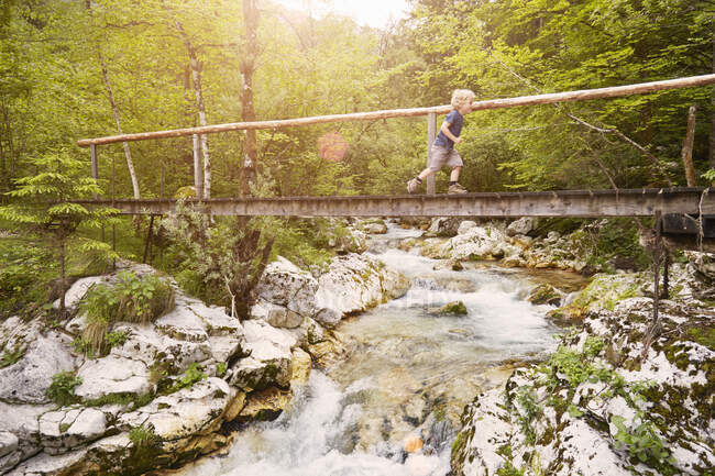 Boy running on wooden footbridge, Bovec, Soca, Slovenia — Stock Photo