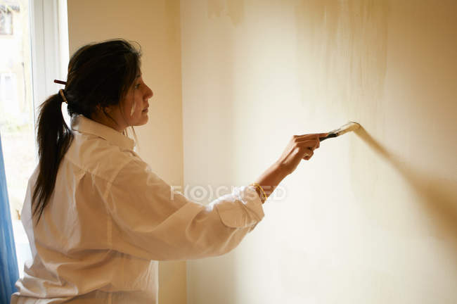 Mujer sala de pintura con pincel - foto de stock