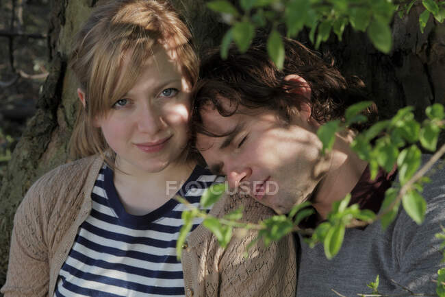 Couple étreignant sous un arbre dans le parc — Photo de stock