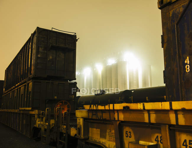 Vista enevoada de tanques de armazenamento industrial entre locomotiva de carga à noite, Seattle, Washington, EUA — Fotografia de Stock