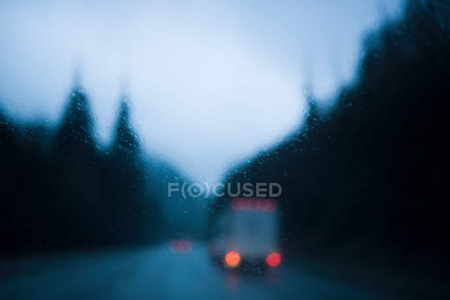 Defocused view of road with truck and raindrops — Stock Photo