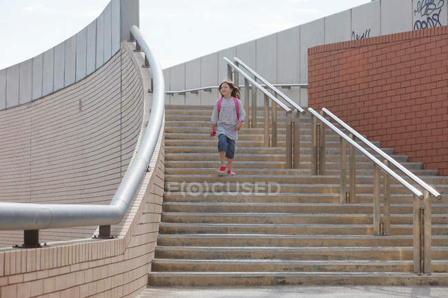 Девушка поднимается по лестнице на открытом воздухе — стоковое фото