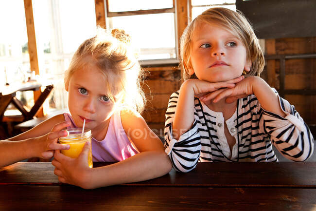 Mädchen trinkt Saft und Junge schaut nachdenklich — Stockfoto