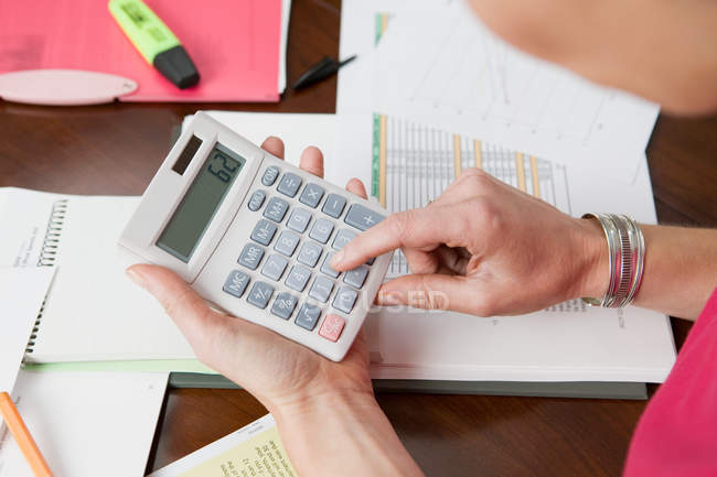Overhead view of Woman using calculator — Stock Photo