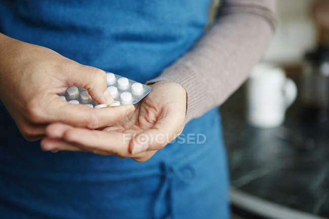 Young woman taking medication from blister pack, close-up — Stock Photo