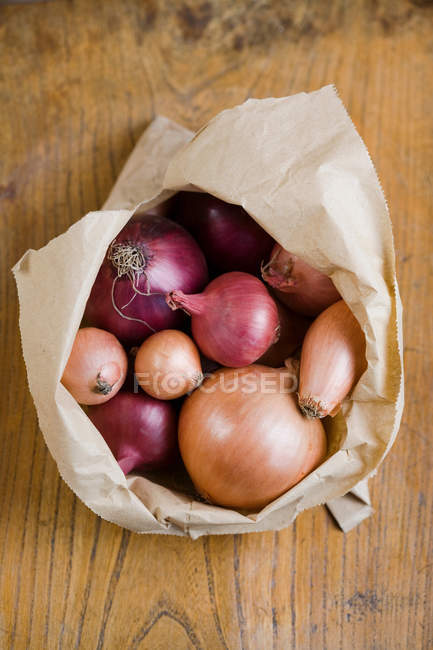 Papiertüte mit gemischten Zwiebeln, Ansicht von oben — Stockfoto