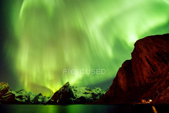 Aurora boreal sobre el mar y las montañas - foto de stock
