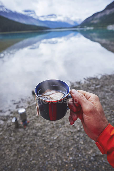 Обрезанный образ человека с горячей чашкой чая — стоковое фото