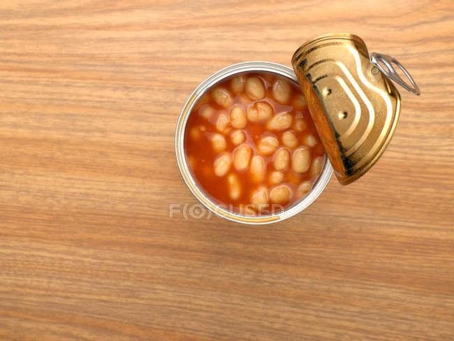 Vista superior da lata aberta de feijão assado na mesa — Fotografia de Stock