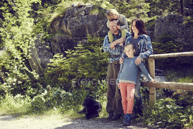 Portrait of family, in forest, standing by fence — Stock Photo