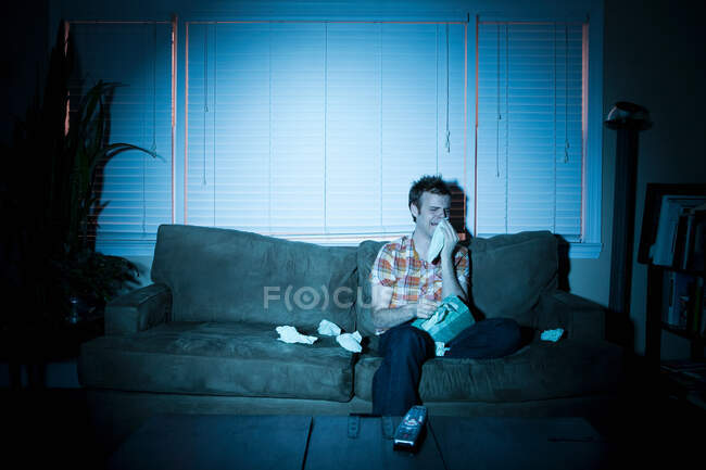 Junger Mann sieht Fernsehen und weint — Stockfoto