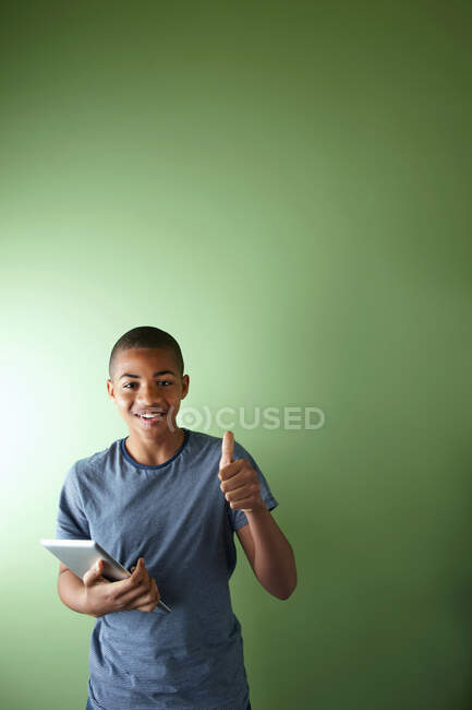 Schoolboy com polegar para cima e tablet digital — Fotografia de Stock