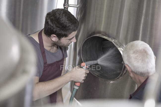 Brauer säubert einen Edelstahltank in der Brauerei — Stockfoto
