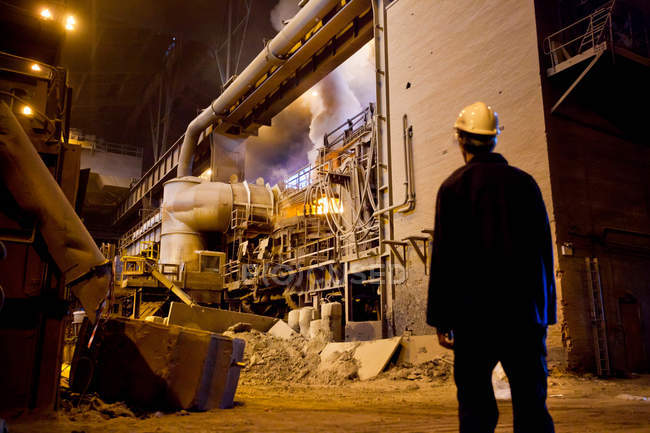 Worker walking in steel forge — Stock Photo