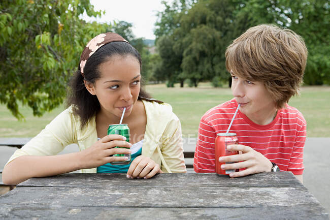 Teenage couple drinking fizzy drinks — Stock Photo