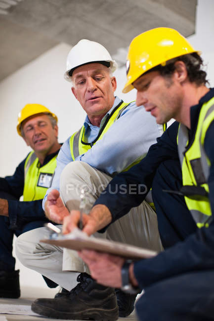 Рабочие разговаривают на стройплощадке — стоковое фото