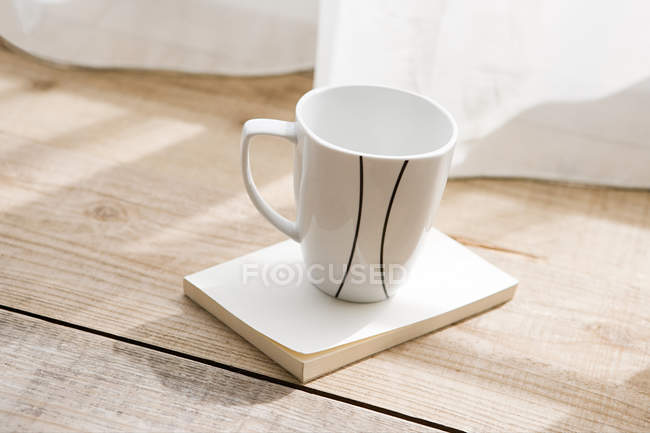 Empty cup on book — Stock Photo