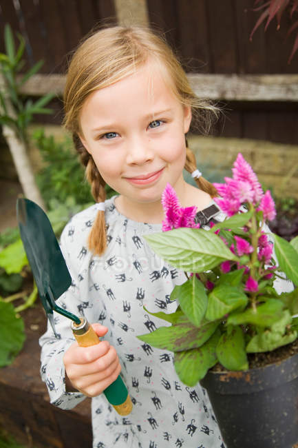 Sorrindo menina plantando flores ao ar livre — Fotografia de Stock