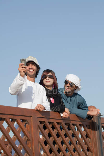Middle Eastern people by fence, low angle view — Stock Photo