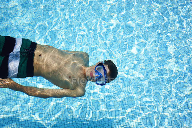 Adolescent garçon portant lunettes dans piscine — Photo de stock