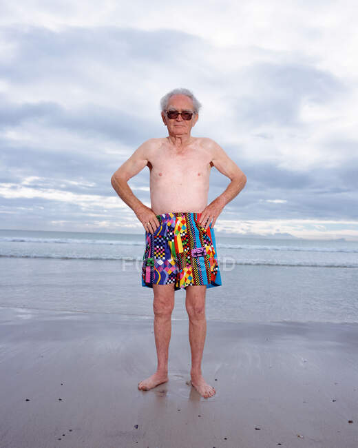 Зрілий чоловік в яскравих шортах на пляжі — стокове фото