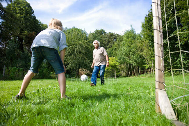 Grandfather tries to score a goal — Stock Photo