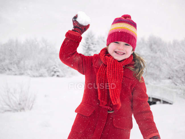 Sonriente chica lanzando bola de nieve - foto de stock