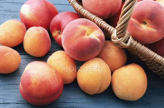Peaches and apricots in basket — Stock Photo