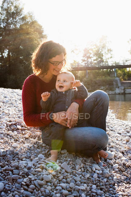 Mother holding baby by creek — Stock Photo