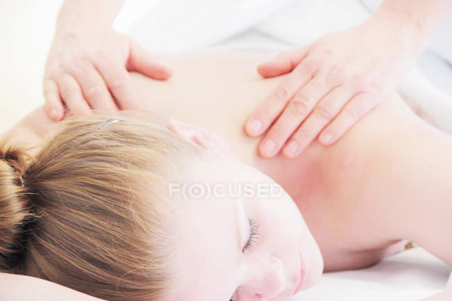 Frau mit Rückenmassage im Wellnessbereich — Stockfoto