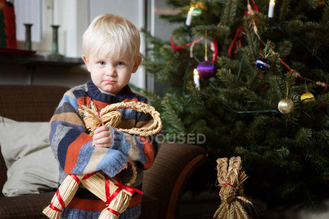 Хлопчик тримає іграшку на ялинці — стокове фото