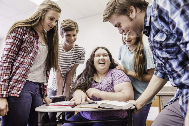 Liceo adolescenti ridere e parlare intorno alla scrivania — Foto stock