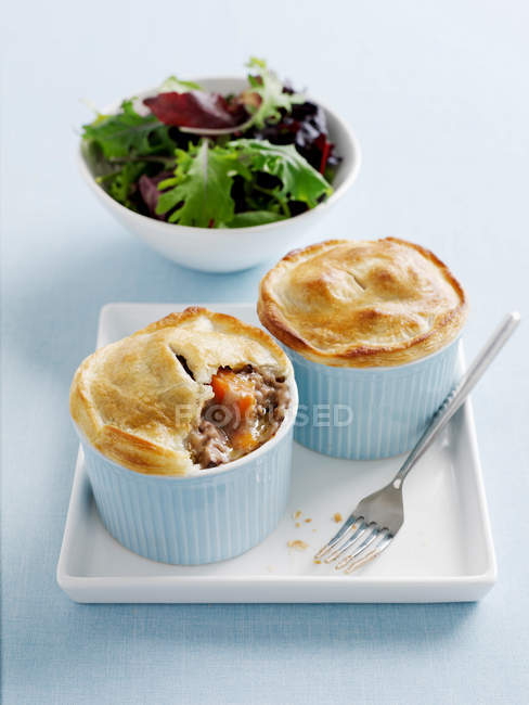 Mini pot pies with salad in bowls — Stock Photo