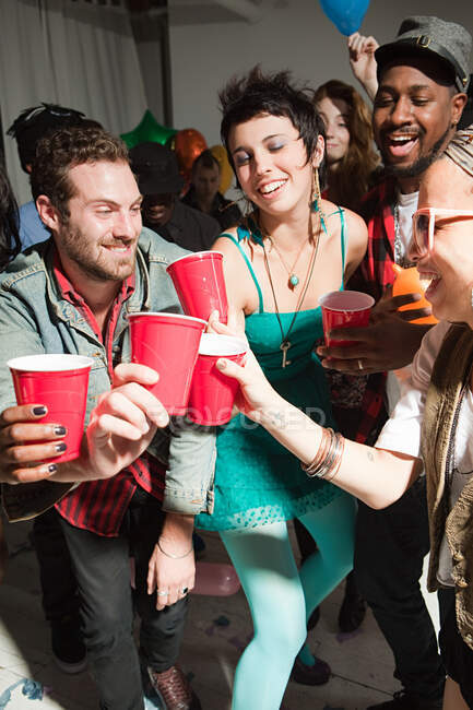 Jóvenes con copas de plástico en la fiesta - foto de stock