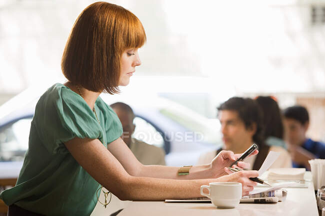 Frau benutzt Mobiltelefon im Café — Stockfoto