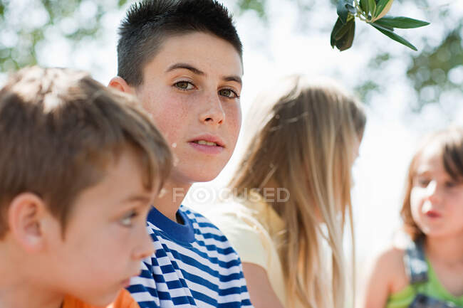 Four friends, older boy looking at camera — Stock Photo