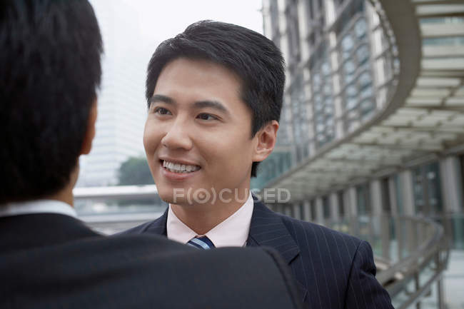 Businessmen talking on walkway — Stock Photo