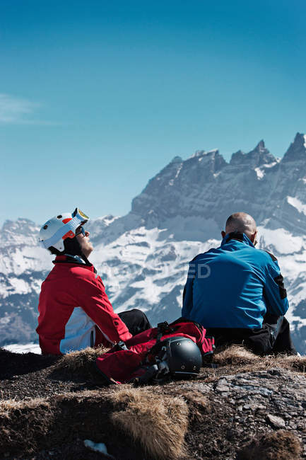 Skifahrer ruhen sich auf felsigem Gipfel aus — Stockfoto