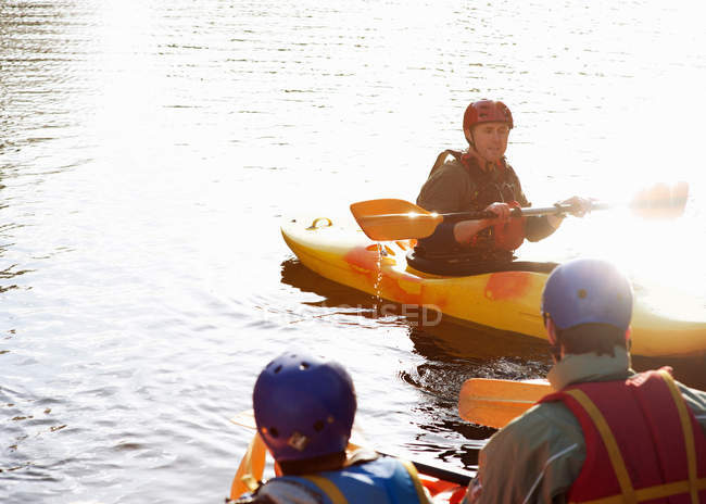 Teacher talking to students in kayaks — Stock Photo