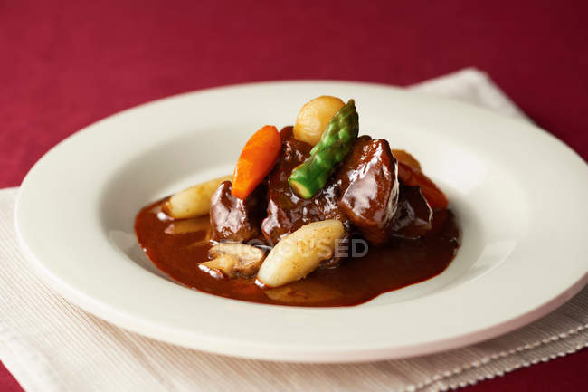 Stew garnished with asparagus and carrot — Stock Photo