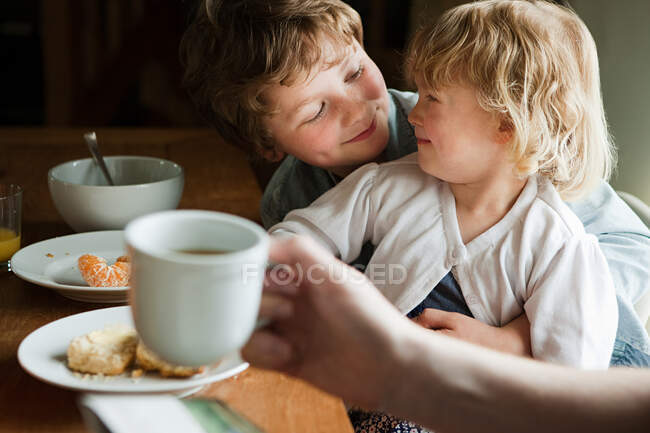 Hermano y hermana desayunando - foto de stock