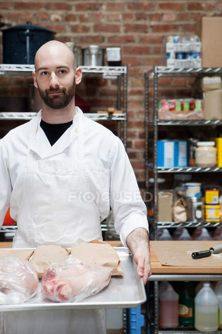 Butcher with tray of meat — Stock Photo