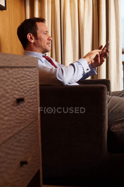 Uomo d'affari al cellulare in camera d'albergo — Foto stock