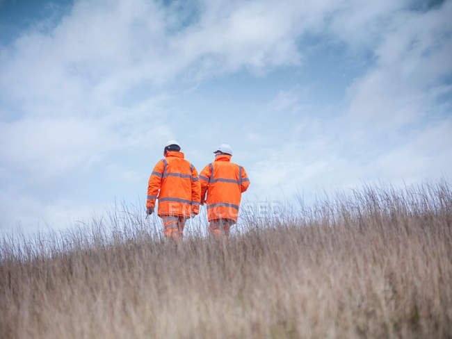 Ecologists at surface coal mine restoration walking away — Stock Photo