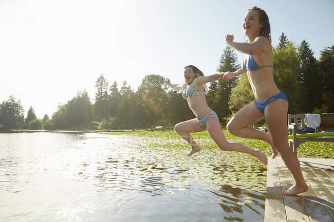 Les filles en bikini sautant dans le lac, Seattle, Washington, États-Unis — Photo de stock