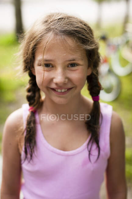 Hochwinkelporträt eines jungen Mädchens mit Zöpfen, das in die Kamera lächelt — Stockfoto