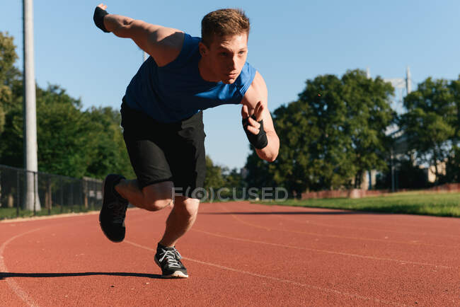Молодий чоловік біжить на спортивній трасі — стокове фото