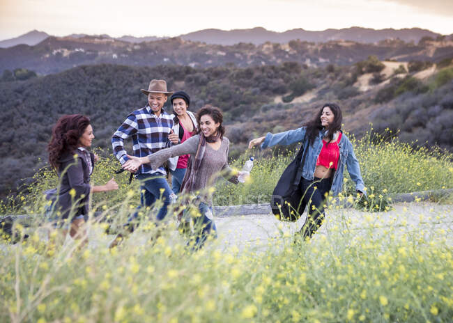 Young man running on rural road with four adult sisters — Stock Photo
