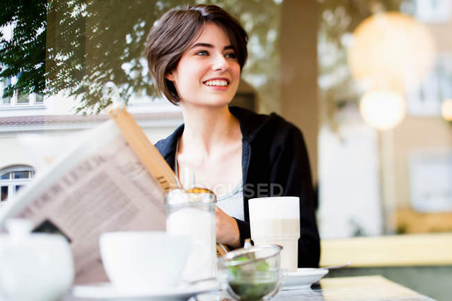 Mulher lendo jornal no café — Fotografia de Stock