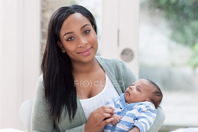 Madre sosteniendo a su bebé - foto de stock